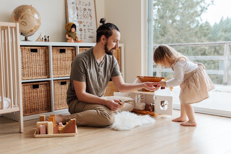 A father and daughter enjoy playtime indoors, sharing a precious parenting moment.