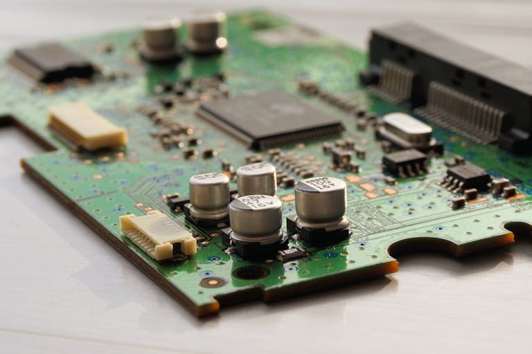 Detailed view of a green circuit board featuring capacitors and microchips.