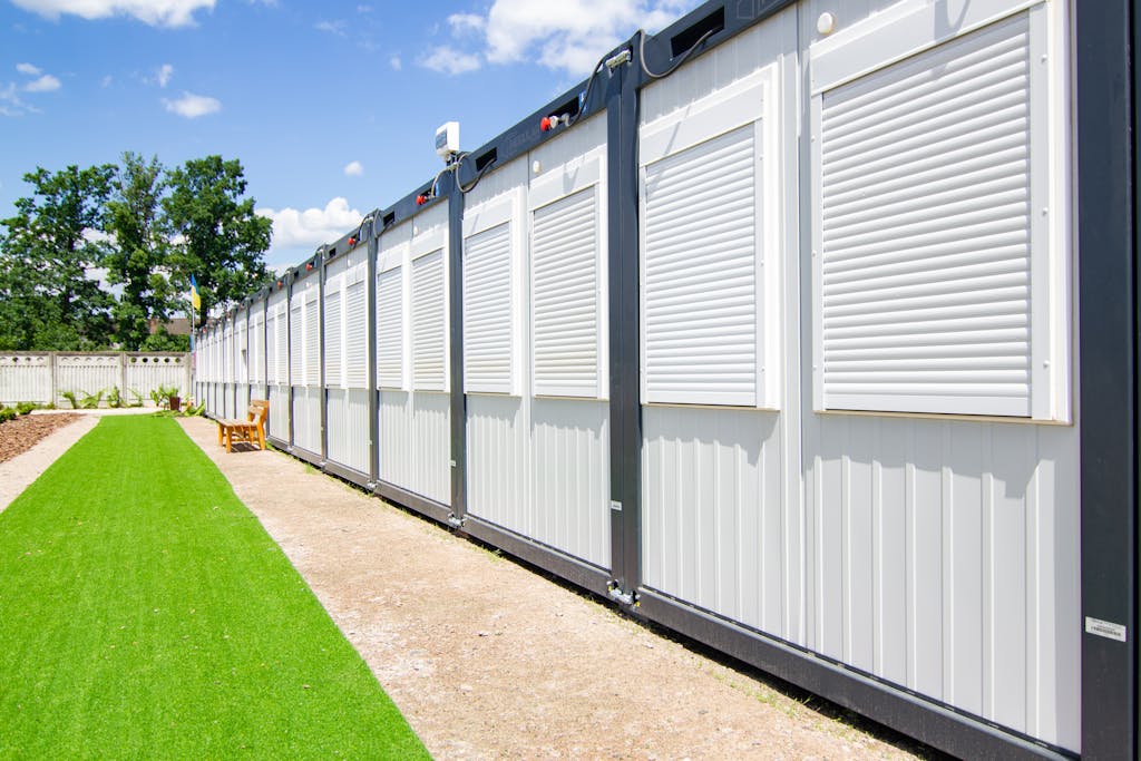 Exterior view of modern container homes with metal siding and adjacent landscaped yard.