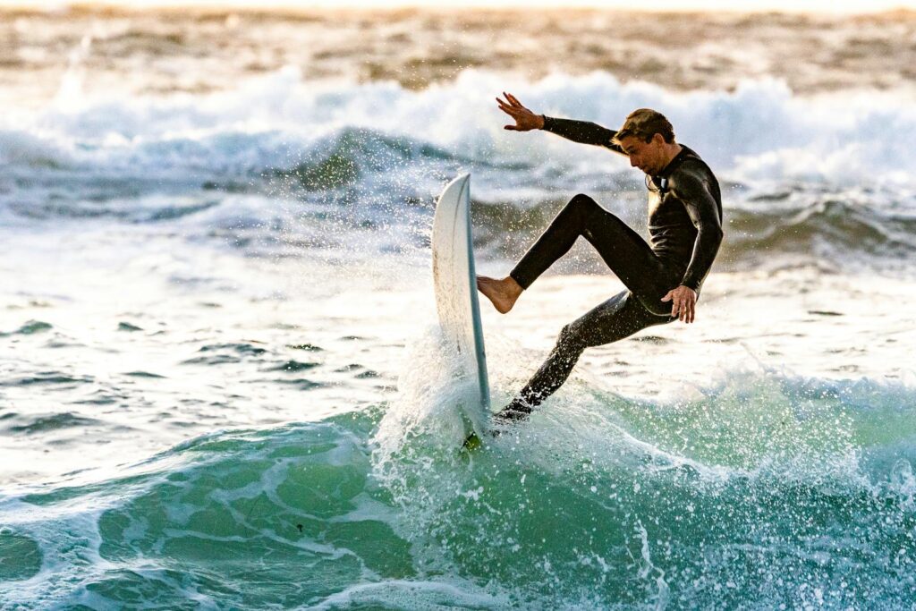 Photo by Guy Kawasaki Energetic surfer performing a trick on ocean waves, showcasing skill and excitement.